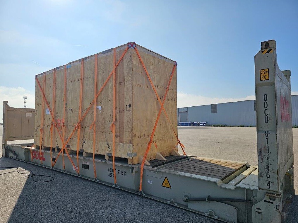 Caisse en bois 4C sanglée sur un flat rack — projet réalisé par INCO'EXP
